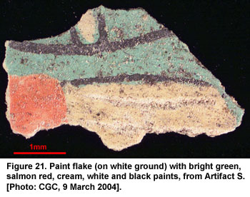 Figure 21. Paint flake (on white ground) with bright green, salmon red, cream, white and black paints, from Artifact S. [Photo: CGC, 9 March 2004].